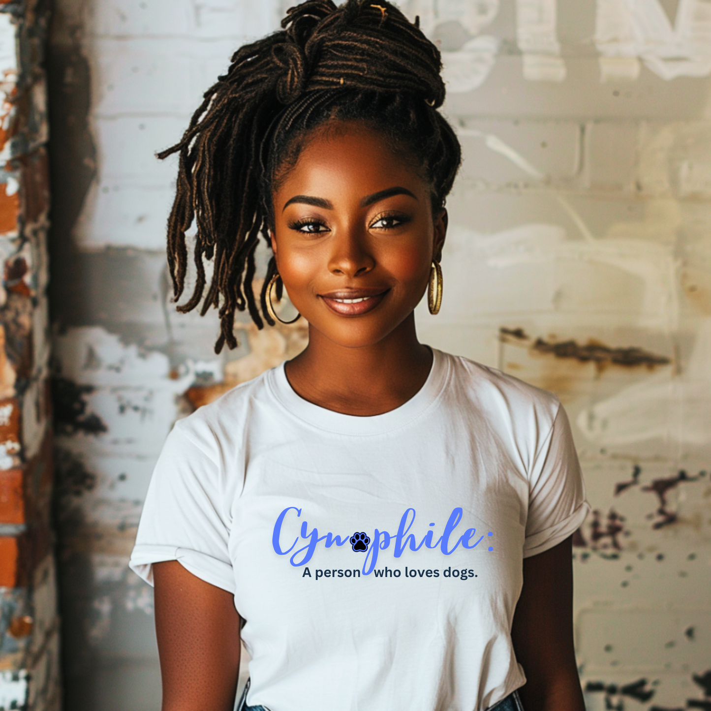 Beautiful, brown woman wearing a white t-shirt with, "Cynophile: A person who loves dogs" written across the front in a blue, cursive font.