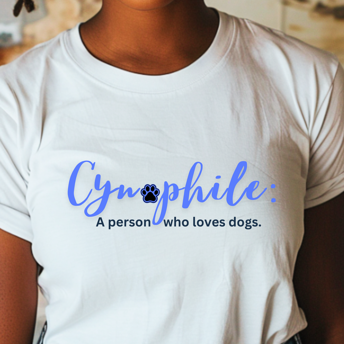 Close up of a woman wearing a white t-shirt with, "Cynophile: A person who loves dogs" written across the front in a blue, cursive font.